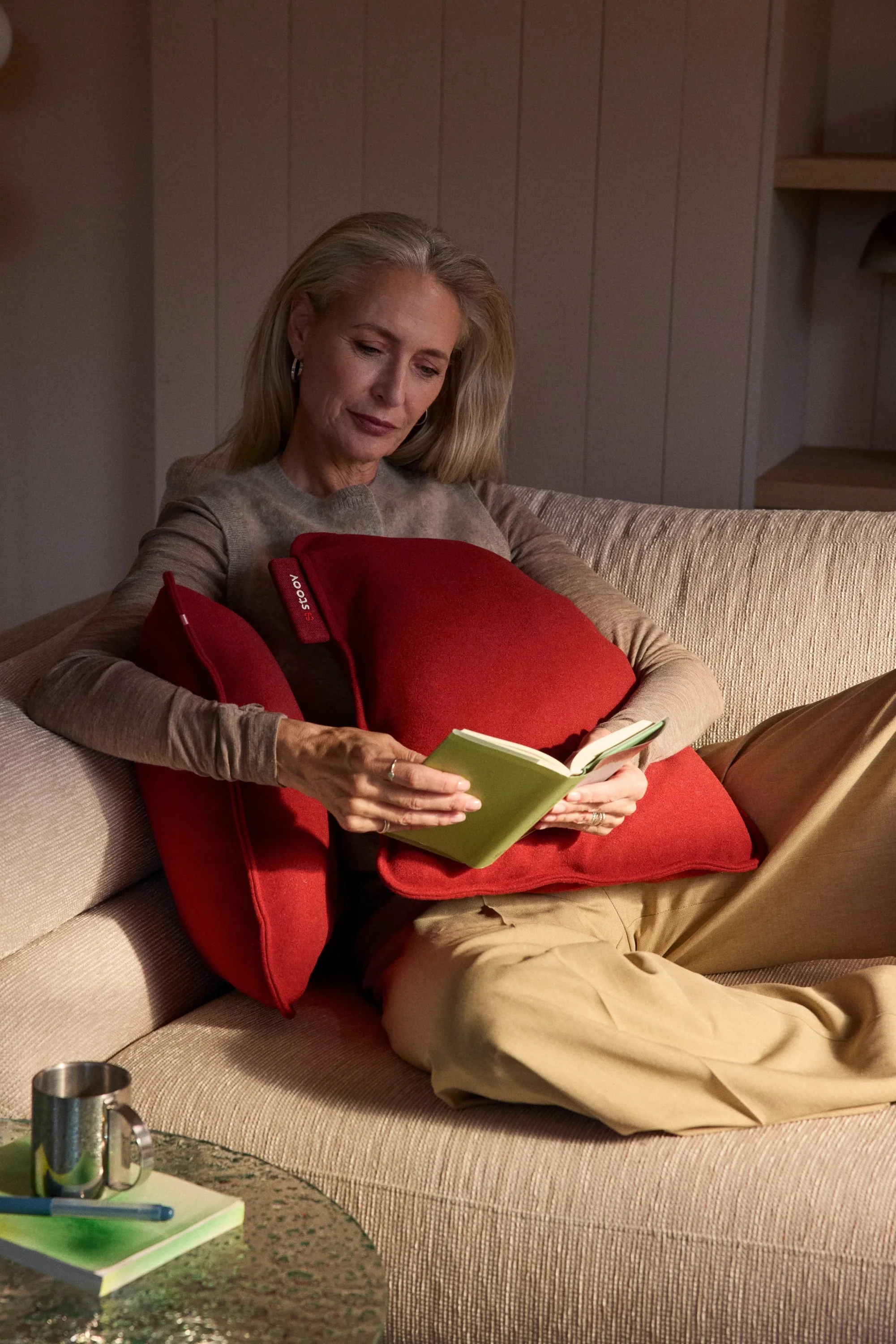 A red Ploov cushion held in a lap
